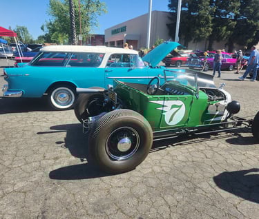 a green car with a number of cars parked in front of it