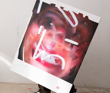 Artist holding a large abstract expressionist painting with red and white brushstrokes in an art studio.