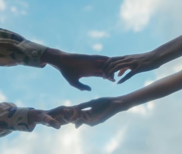 Twee handen reiken naar elkaar en grijpen elkaar vast, symbool voor verbinding en steun