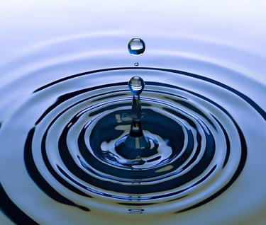 Close-up van waterdruppel die cirkelvormige ringen maakt, symboliseert impact en effect