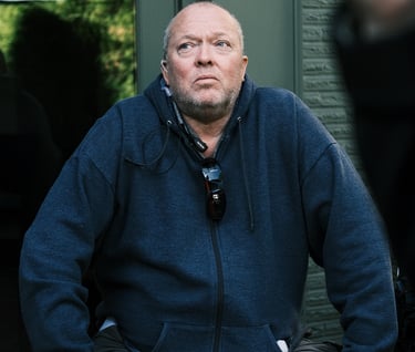 Director of Photography (DP) at a film studio, man seated on a bench in a park
