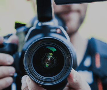 a man holding a camera and taking a picture of a camera