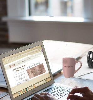 a person sitting at a desk with a laptop and a cup of coffee