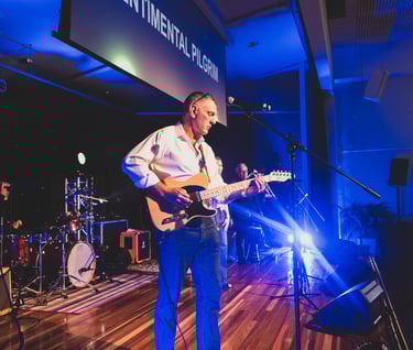 a man playing guitar in a band