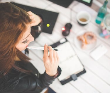 a woman sitting at a desk with a pen and a pen