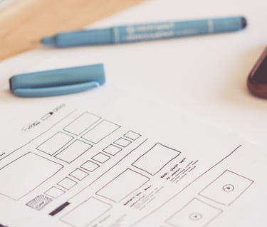 a paper wireframe and pen on a desk