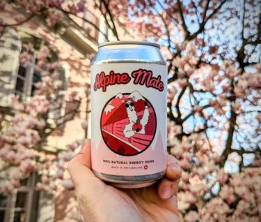 Une canette de boisson énergisante naturelle Alpine Mate devant des cerisiers