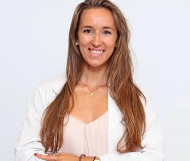 a woman in a white shirt and jeans standing in front of a white wall
