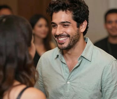 A warm, candid shot of Lyan Galindo sharing a smile with a guest after a show. The composition is inviting and warm, with soft lighting highlighting the #E6EBE0 and #91AA9D tones in their clothing and the background.