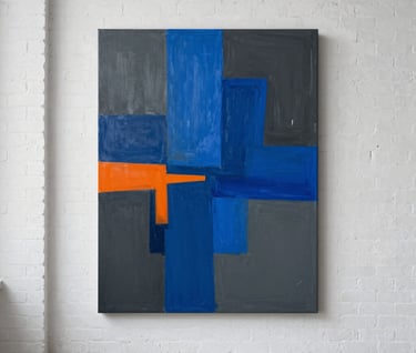 A finished large-scale abstract painting hanging on a white brick wall in a International / Urban Art Scene loft. The painting features bold monochromatic blue strokes over a deep slate grey and charcoal base, with sharp safety orange geometric accents. Minimalist and high-end aesthetic.