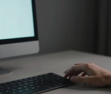 Lifestyle photography of a South American designer working at a high-end minimalist desk. The scene is captured in soft focus, with a palette of blacks, greys, and a hint of baby blue from a monitor screen. Sophisticated and modern mood.
