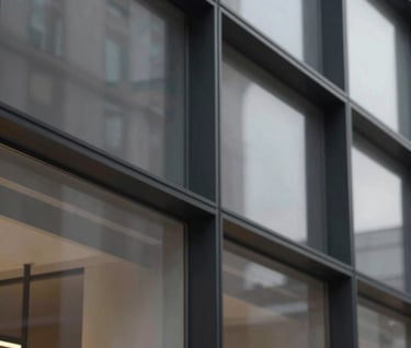 An abstract, geometric architectural detail of a glass-and-steel flagship storefront. Strong contrast, clean lines, editorial composition. Sophisticated and confident mood with deep charcoal #111111 tones.