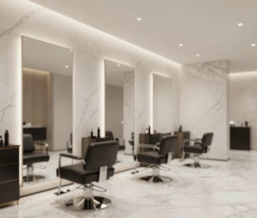 Lifestyle shot of a modern, high-end hair salon or beauty space, emphasizing clean lines, marble textures #FDFBF7, and a sophisticated atmosphere with no people in the frame, wide angle.