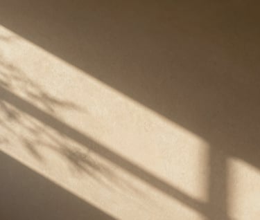 Abstract shot of sun-drenched light patterns on a soft sand colored wall in a North American / US apartment. Cinematic shadows.
