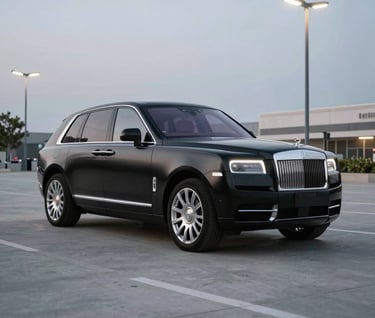 A high-performance luxury vehicle in matte black with chrome accents, parked in a minimalist North American urban plaza under cold white streetlamps. Sharp focus, edgy atmosphere.