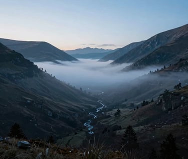 A professional landscape photograph of a misty valley at dawn. Shades of soft blue and dark charcoal dominate the frame, creating a serene and sophisticated visual experience.