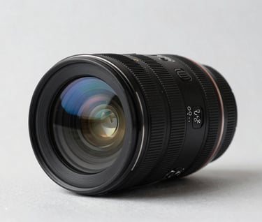 An elegant still life photograph of a high-end camera lens sitting on a mist white surface. The composition is minimalist with soft blue reflections in the glass and sharp, professional detail.