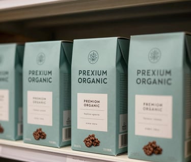 A minimalist retail shelf in a North American / US boutique boutique grocery store displaying several identical boxes of premium organic snacks with modern branding in muted teal and mist.