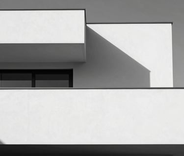 Minimalist architectural detail of a luxury villa, geometric shadows on a white wall, cinematic black and white composition, Global / Hispano context, clean lines and premium feel.