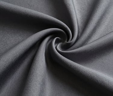 Macro photography of draped heavy silk fabric, focusing on texture and deep shadow, North American / European studio, soft side lighting, neutral grayscale tones including medium gray and deep black.