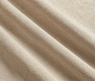 Close-up photography of a thick linen fabric texture in a soft sand color, professional studio lighting, minimalist and sophisticated feel, European / Spanish design.