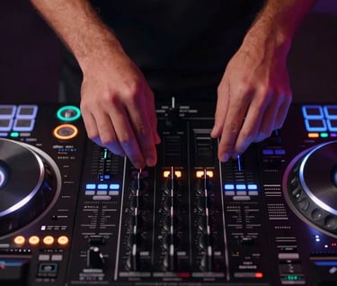 Top-down view of DJ decks and hands with #7A7CF1 glowing light reflections on buttons and sliders, professional dark equipment, nightlife atmosphere.