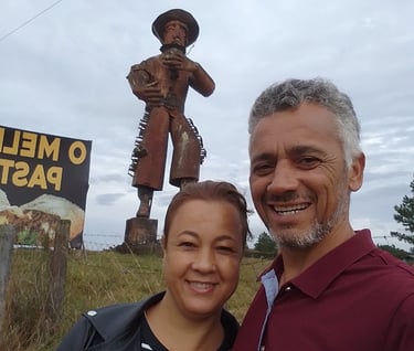 Foto de Adriano e Andréa, ao fundo, escultura de meta Gaúcho gigantel