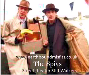 The Spivs street theater performers on stilts wearing vintage trench coats and hats.