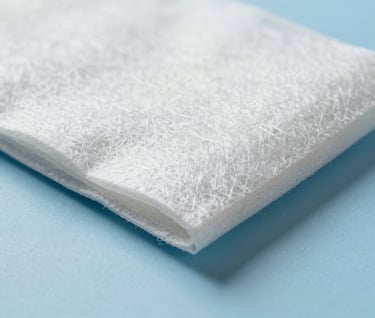 Close up of sustainable packaging material showing fiber texture, lit to highlight shadows and depth, clean and professional, #ECF0F1 and #8D9FB5.