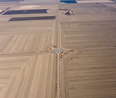 Aerial photography of a vast rural plot in Northeast Nevada. The shot captures the strategic layout of the land including natural drainage and access roads in professional sand beige tones.