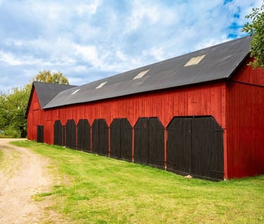 Old wooden barn painted with breathable heritage paint, showing natural aging without peeling or cracking