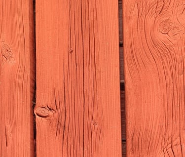 Close-up of exterior wood boards painted with breathable natural paint showing grain and knots