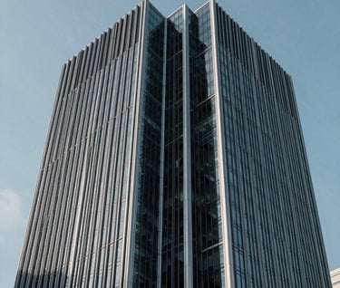 Architectural detail of a modern steel and glass skyscraper in a North American / US city, emphasizing sharp angles and a minimalist aesthetic under a cool sky blue light.