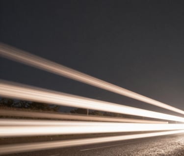 A creative long-exposure photograph of light trails at night. The streaks of light are a warm taupe and soft off-white, set against a deep dark slate grey background, giving a sense of fast, chaotic movement.