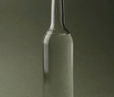 A vertical study of a single tall glass bottle partially filled with water, creating subtle distortions. The style is clean and professional with a muted olive and deep charcoal color scheme.