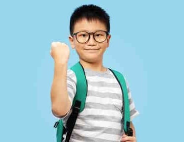 boy with school backpack wearing glasses giving fist pump
