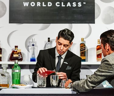 a man in a suit and tie is pouring a drink
