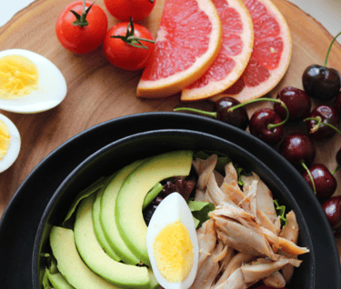 a bowl of fresh vegetables and fruits on table