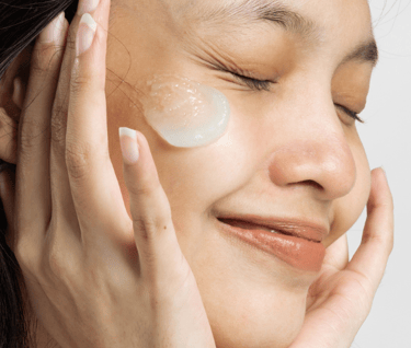 a girl smiling and moisturize is on her face 