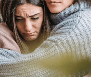 two womens hugging 
