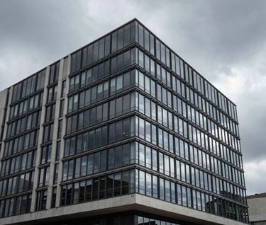A cinematic wide shot of a modern minimalist building facade in Brazil. High-contrast architectural photography showing clean lines and glass surfaces under a moody gray sky.