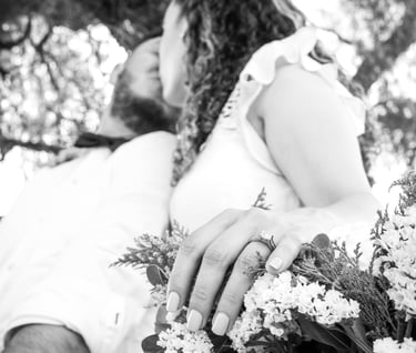 a man and woman holding flowers in a tree