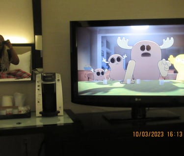 Girl sitting on a bed in the mirror watching cartoons