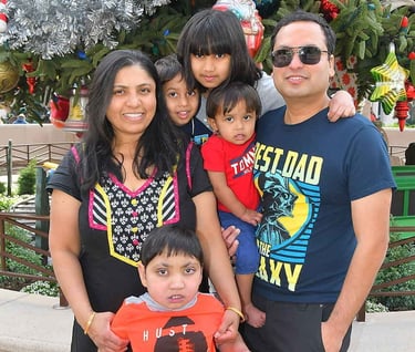 a family posing for a picture in front of a christmas tree