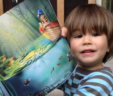 a young boy is holding a book in his hands