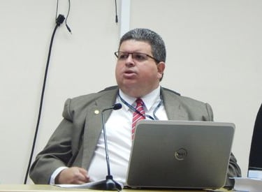 a judge in a suit and tie is sitting at a table