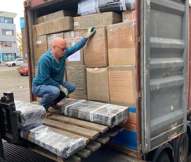 a Fred Nieberg  is standing on a container truck with a lots of Pinoy Balikbayan Boxxes