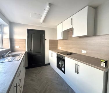a kitchen with a stove top oven and a sink