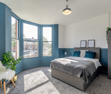 a bedroom with a bed and a chair