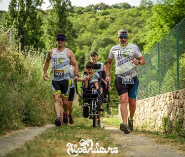Two runners pushing a child in a racing wheelchair during an outdoor inclusive trail running event.